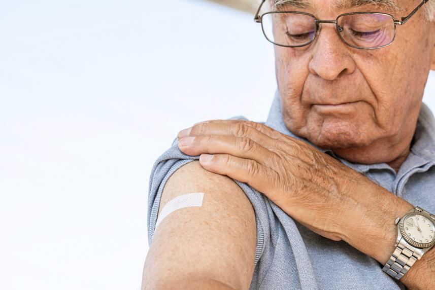 Man looking at his bandaid