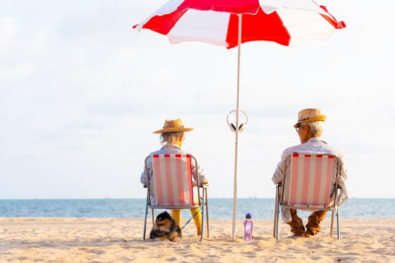 Seniors sitting under umbrella at the beach